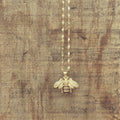 Gold Bumble Bee Necklace by Rooted Home Goods featuring a delicate bee pendant on a fine chain.