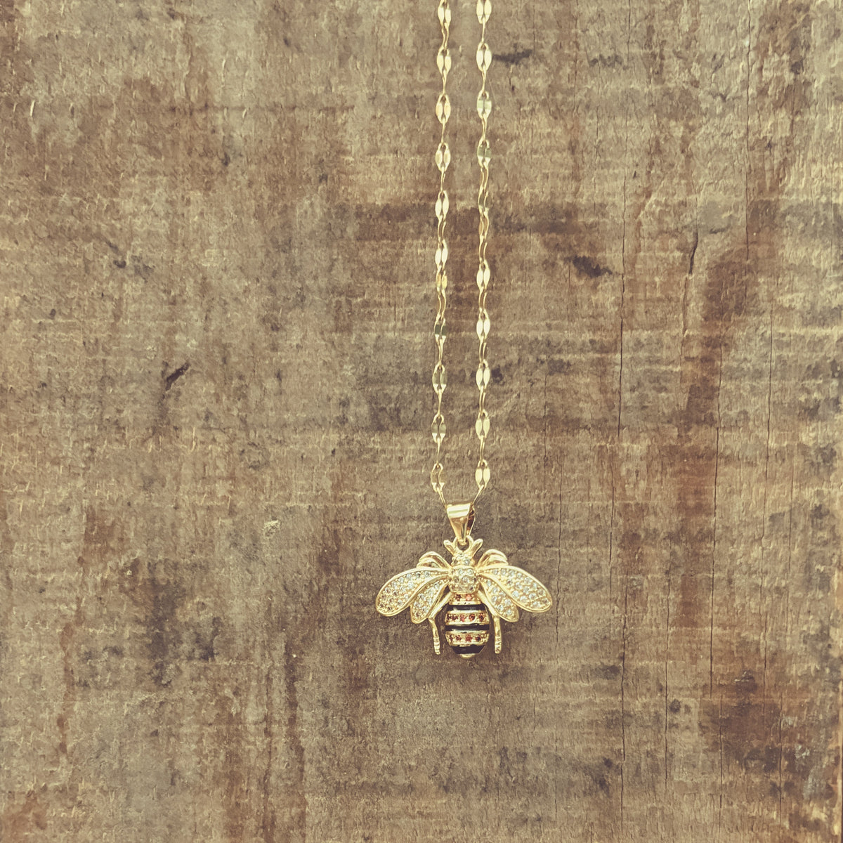 Gold Bumble Bee Necklace by Rooted Home Goods featuring a delicate bee pendant on a fine chain.