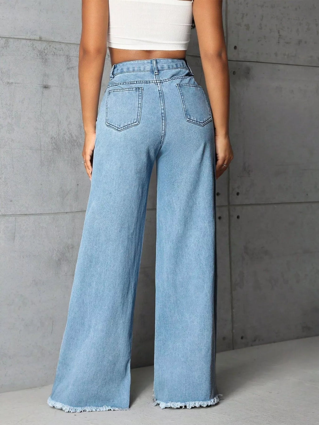 Plus size high-waisted wide-leg raw hem jeans by Trendsi, showcasing full length denim with relaxed fit and raw hem detail.