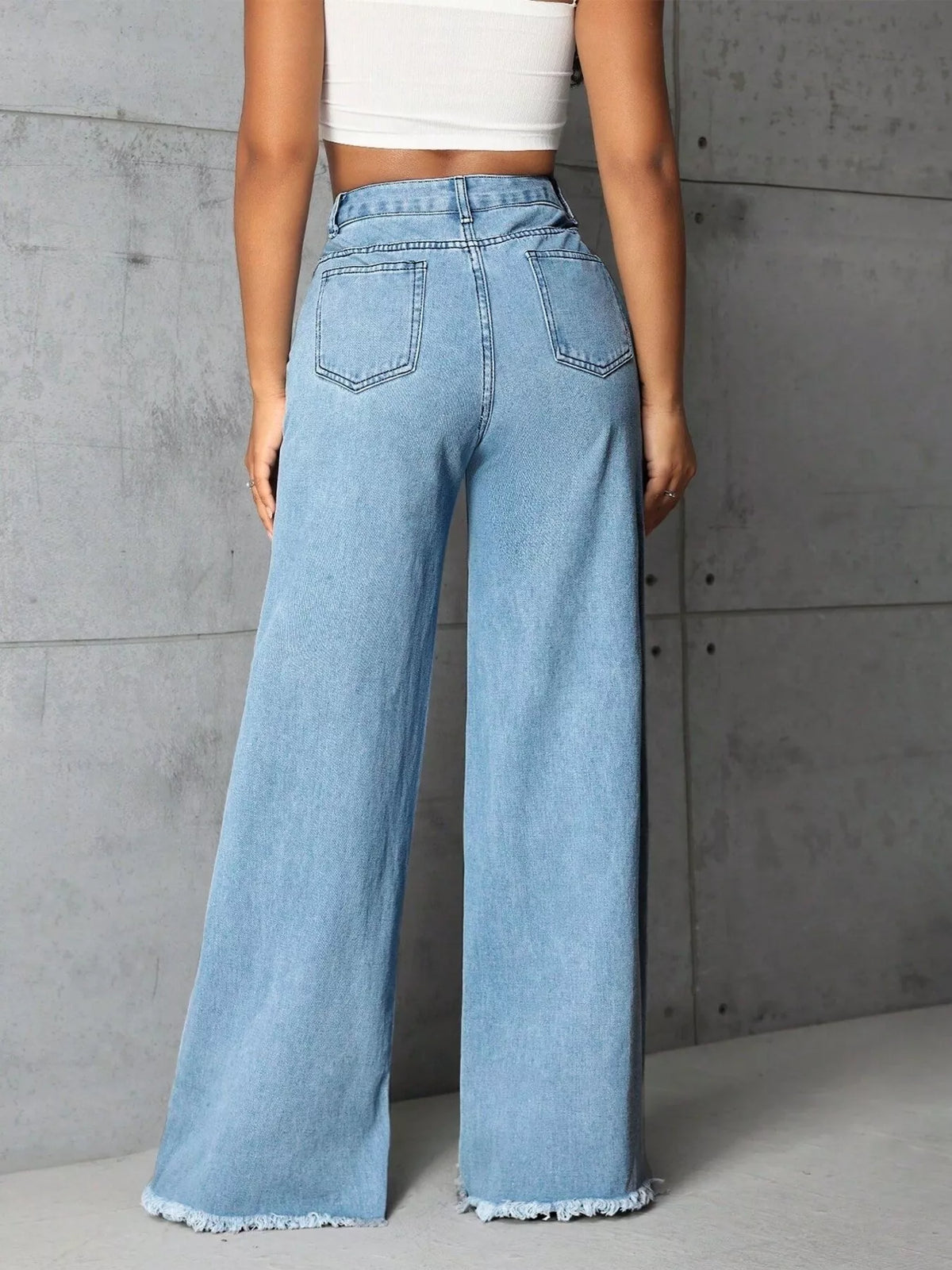 Plus size high-waisted wide-leg raw hem jeans by Trendsi, showcasing full length denim with relaxed fit and raw hem detail.
