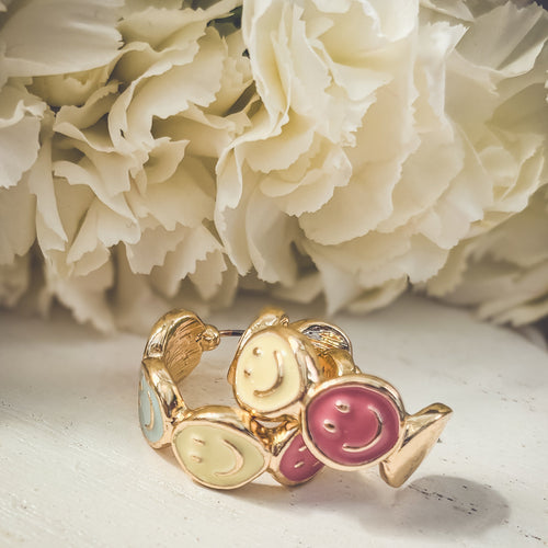 Gold hoop earrings with cute smiley face charms, stylish and playful jewelry by Rooted Home Goods.