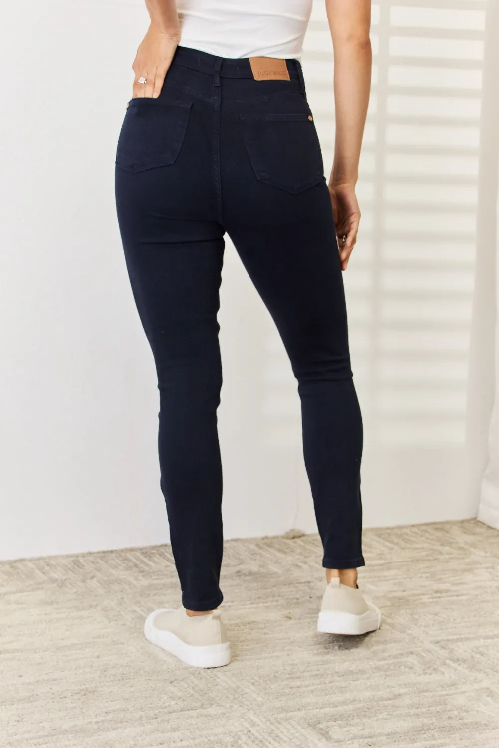 Trendsi Judy Blue full size garment dyed tummy control skinny jeans displayed on a model, showcasing fit and denim texture.