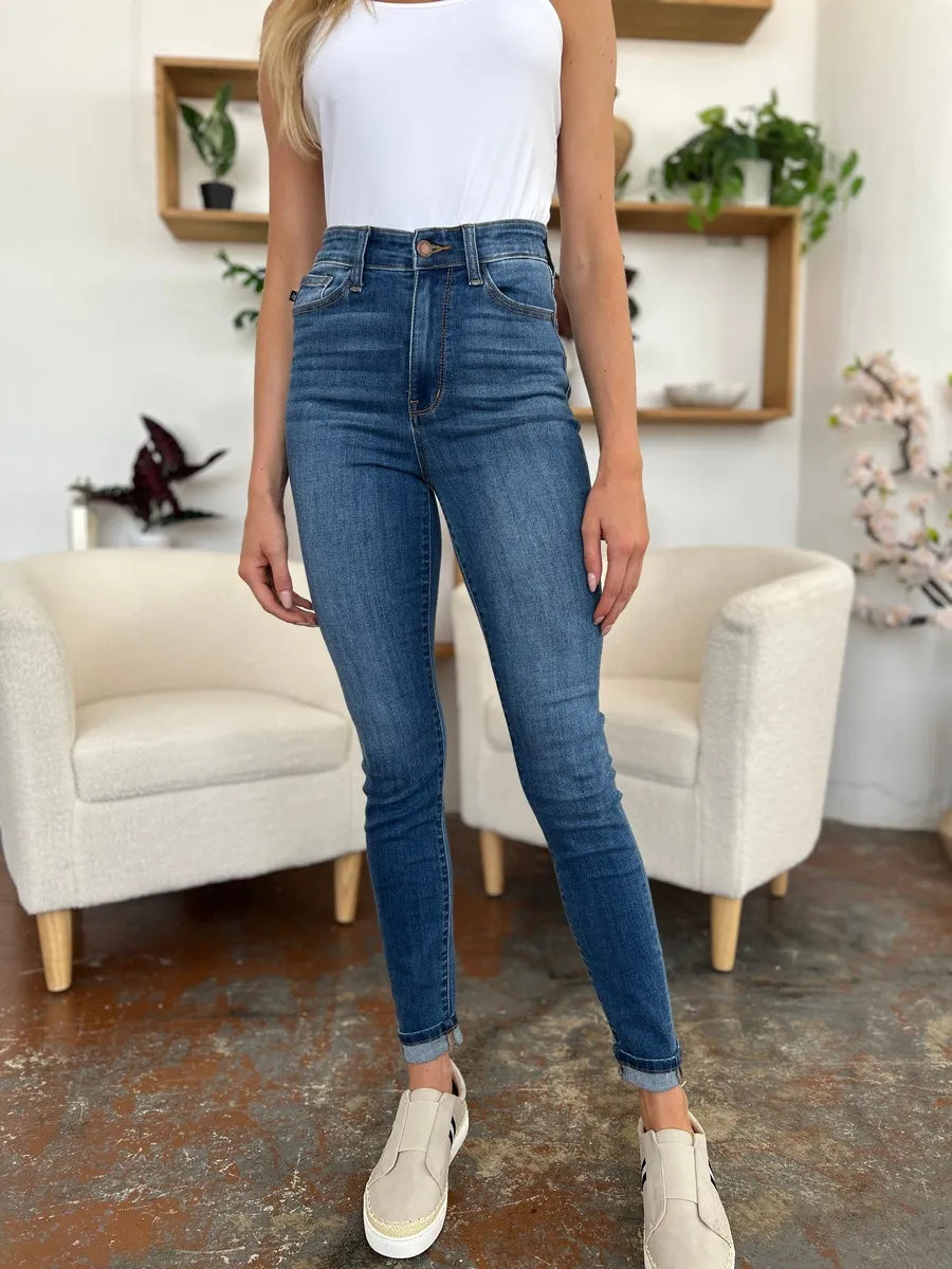 Judy Blue full size cuffed hem skinny jeans displayed on a hanger, showcasing their fitted style and dark wash.