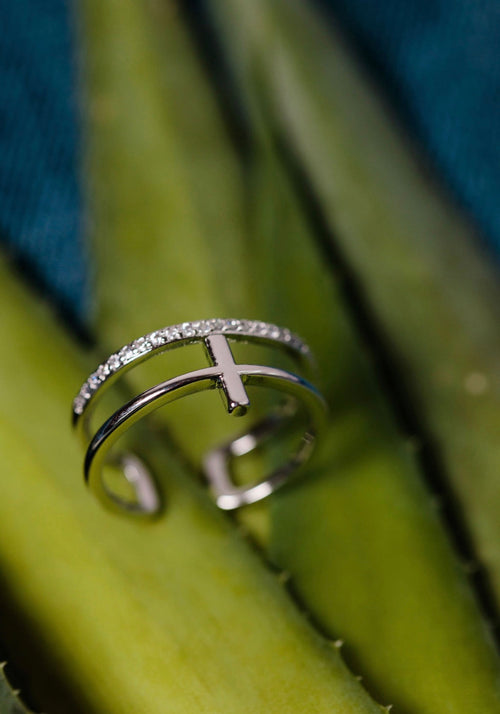 Silver cross ring by TLD Designs featuring a sleek, polished cross design on a shiny silver band.